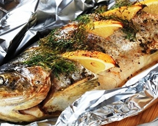 Форель фаршированная овощной смесью и ломтиками лимона